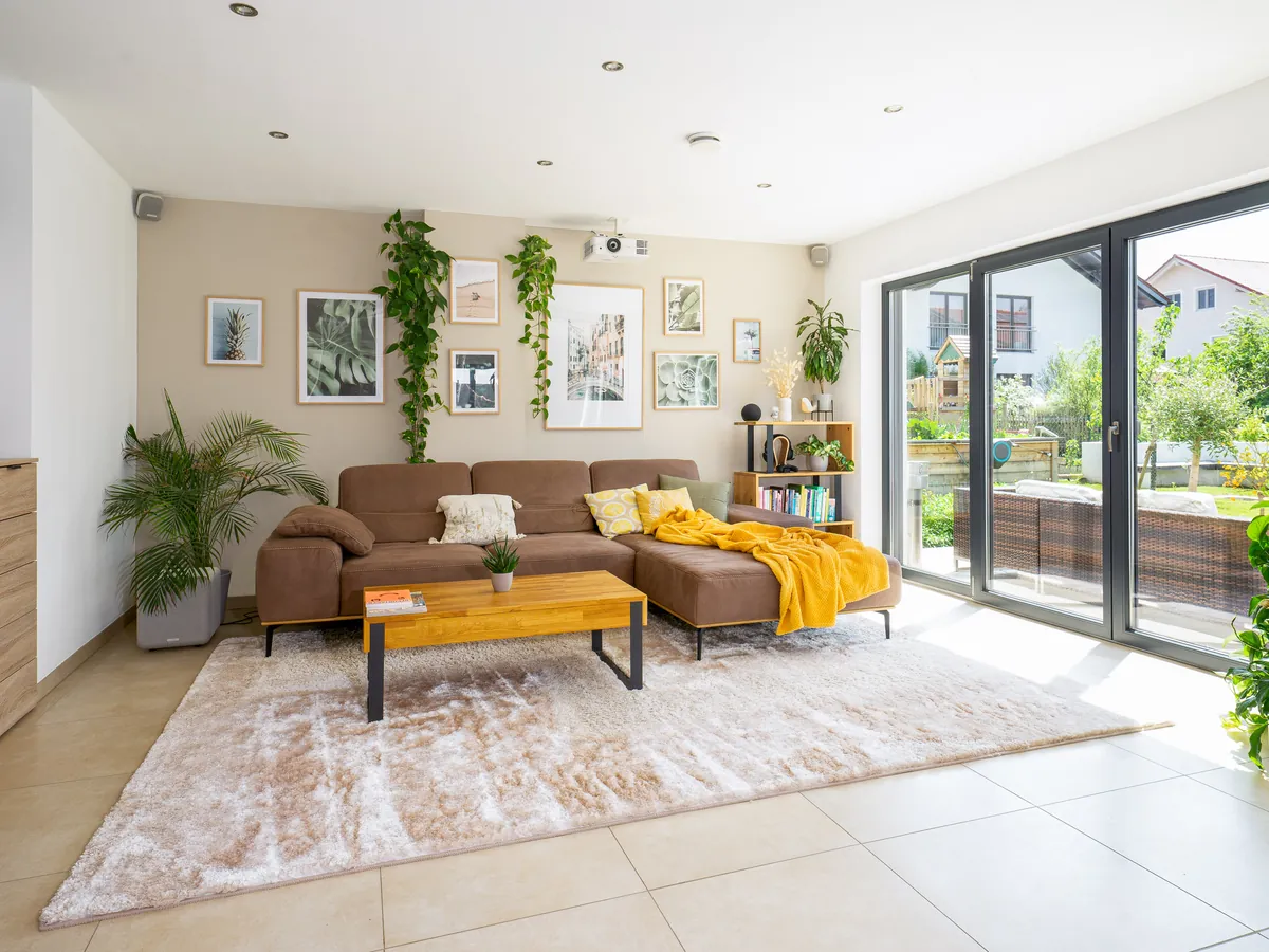 Wohnzimmer mit Ecksofa und großer Terrassentür